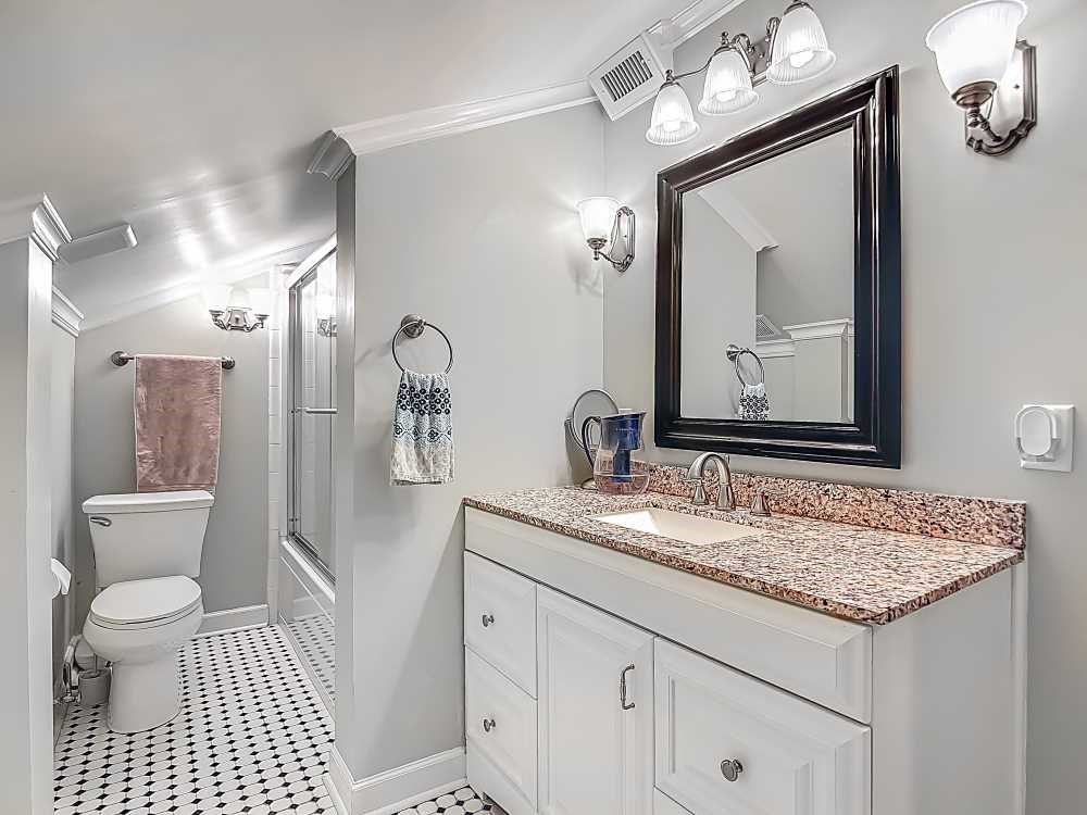 7330 36th Court Vero Beach, FL 32967 - Photo 18 of 33 a bathroom with a granite countertop sink a toilet and a mirror