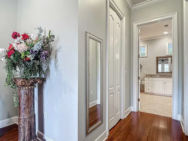a view of a hallway with wooden floor and a dining room