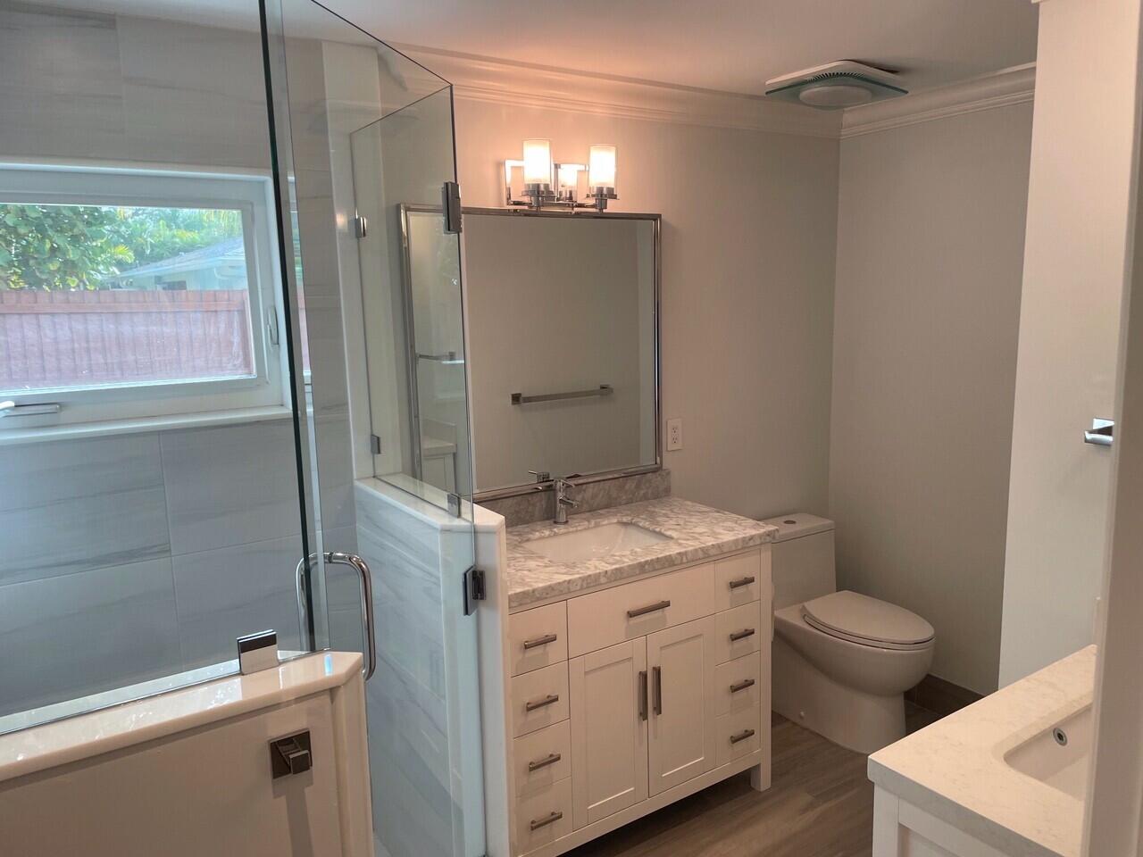 1611 Treemont Avenue Jupiter, FL 33469 - Photo 11 of 28 a bathroom with a granite countertop sink toilet and shower