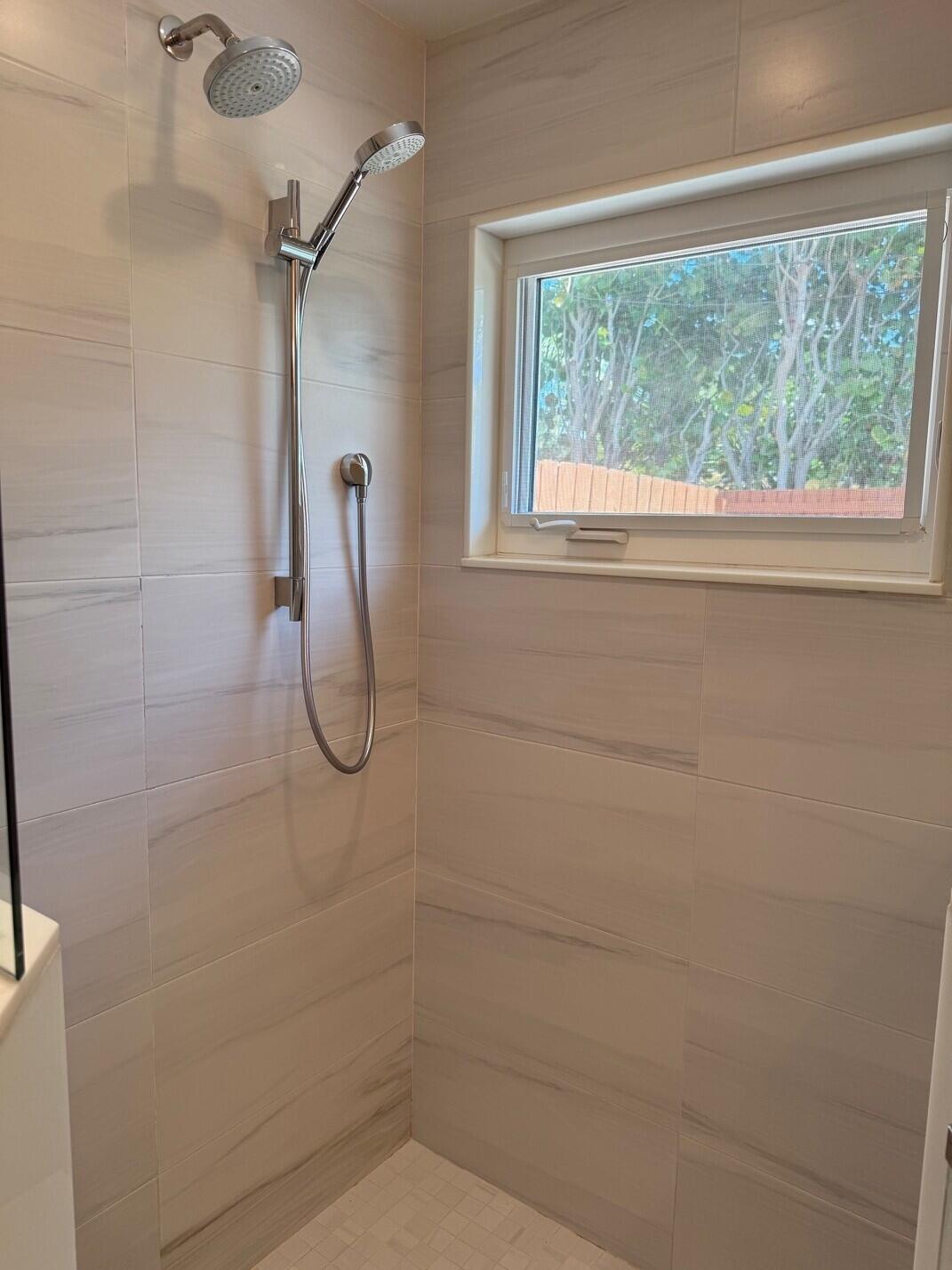 1611 Treemont Avenue Jupiter, FL 33469 - Photo 12 of 28 a bathroom with a glass shower door