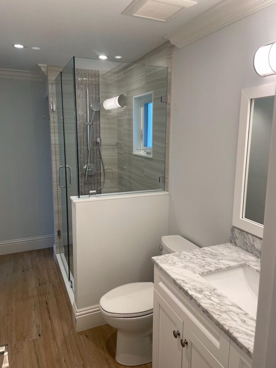 1611 Treemont Avenue Jupiter, FL 33469 - Photo 23 of 28 a bathroom with a granite countertop sink a toilet a mirror and shower