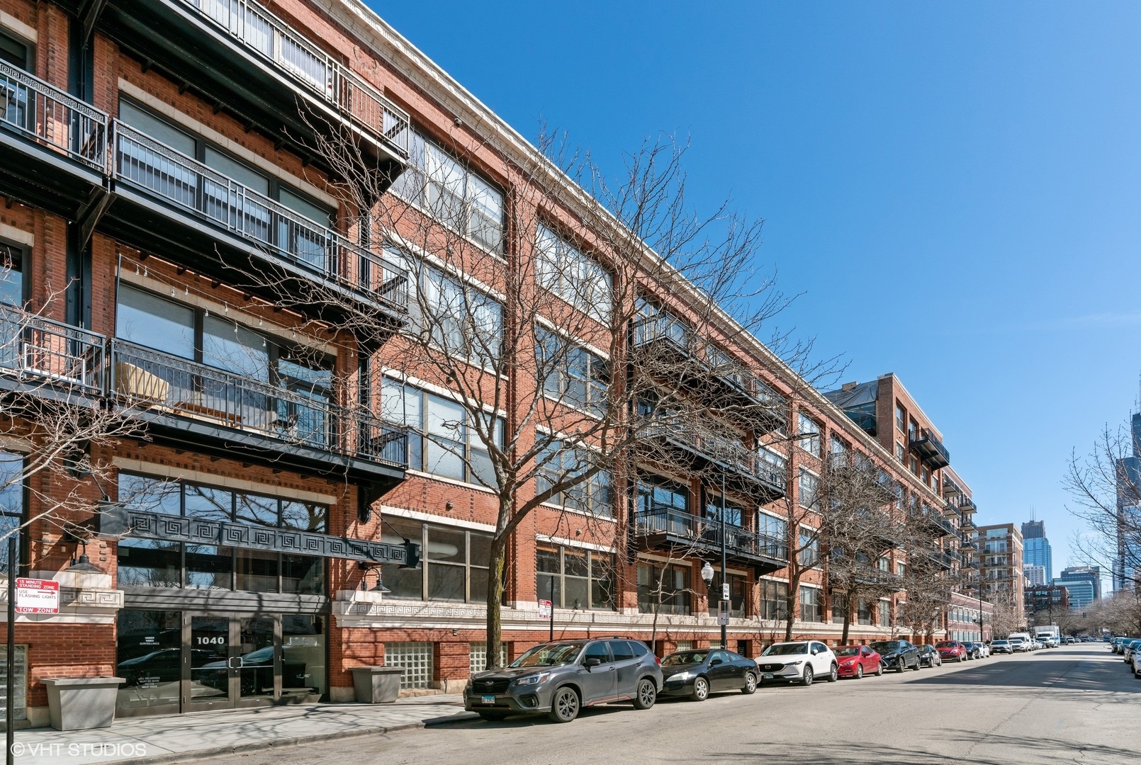 1040 West Adams Street, Unit 107 Chicago, IL 60607 - Photo 1 of 14 a city street lined with buildings and a cars parked on the road