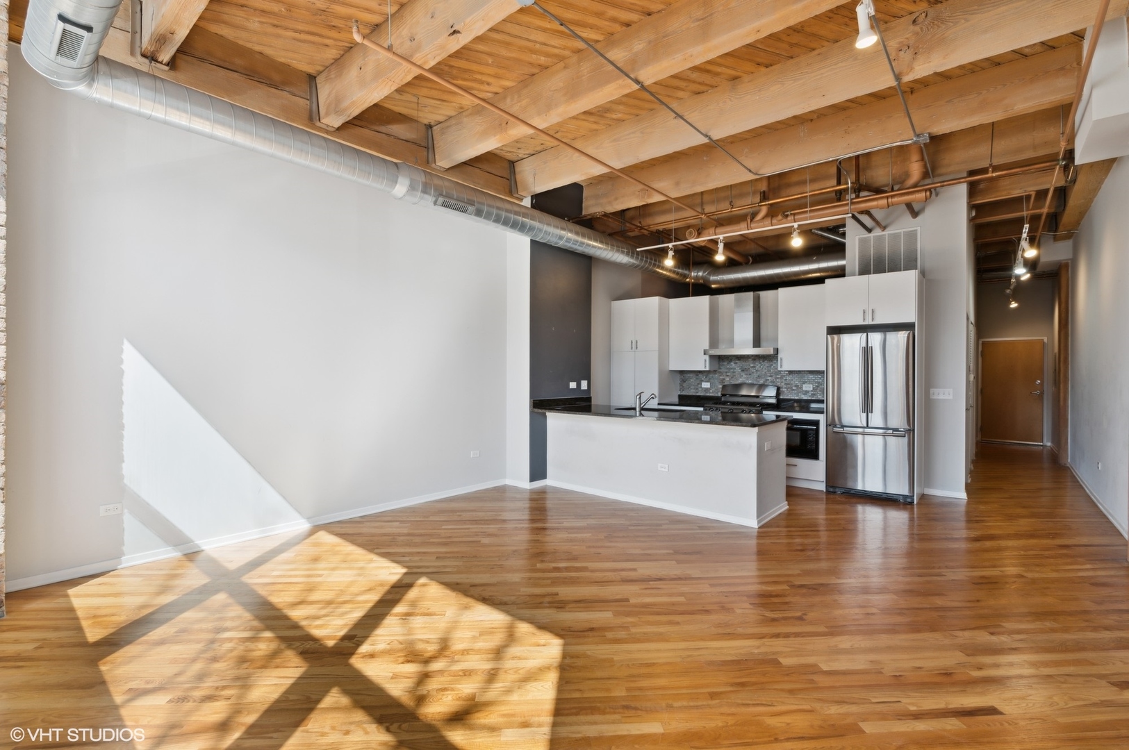 1040 West Adams Street, Unit 107 Chicago, IL 60607 - Photo 6 of 14 a kitchen with stainless steel appliances kitchen island granite countertop a refrigerator and a stove top oven