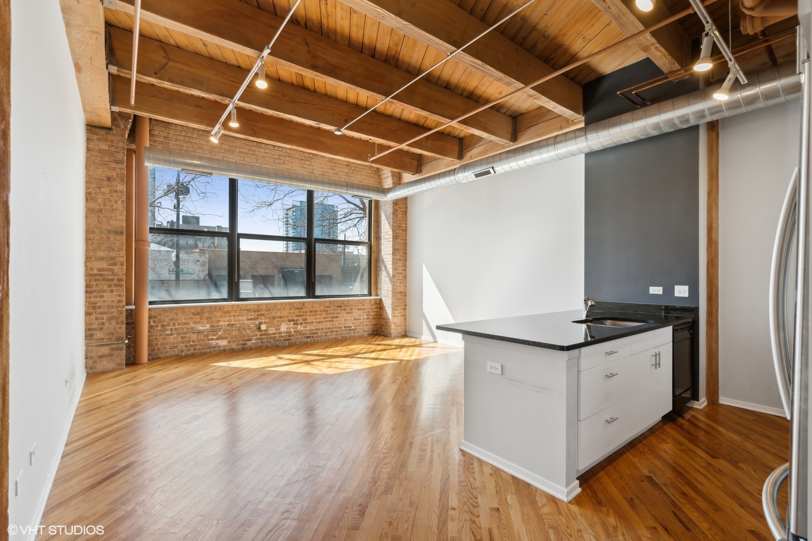 1040 West Adams Street, Unit 107 Chicago, IL 60607 - Photo 9 of 14 a view of a kitchen with a sink and wooden floor