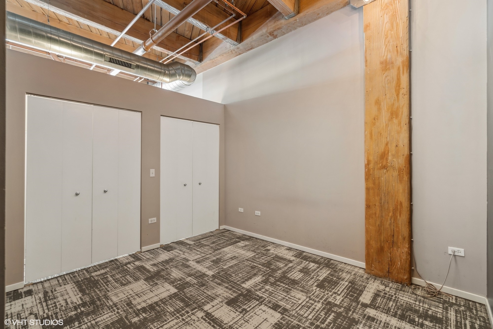 1040 West Adams Street, Unit 107 Chicago, IL 60607 - Photo 10 of 14 a view of a room with a bed and wooden floor