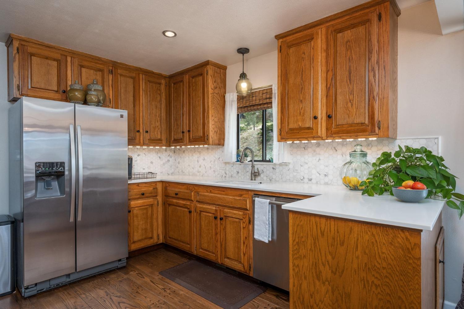 42538 Buckeye Road Oakhurst, CA 93644 - Photo 20 of 46 a kitchen with stainless steel appliances granite countertop a sink a refrigerator and a wooden cabinets