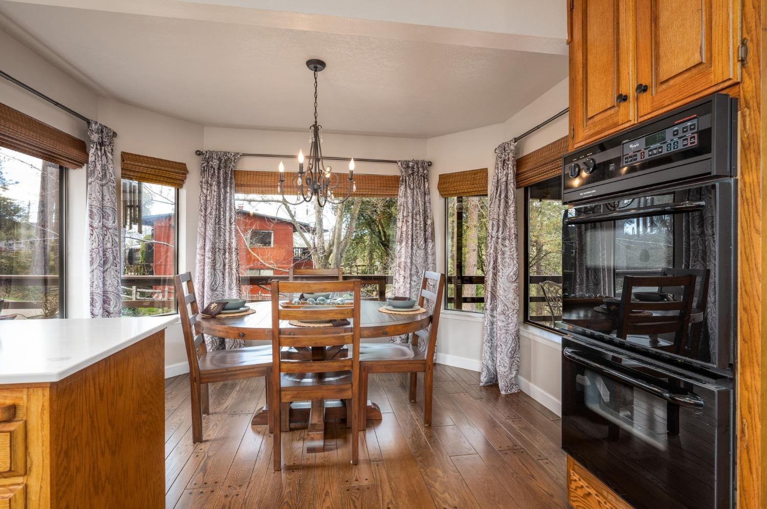 42538 Buckeye Road Oakhurst, CA 93644 - Photo 21 of 46 a view of a dining room with furniture window and wooden floor