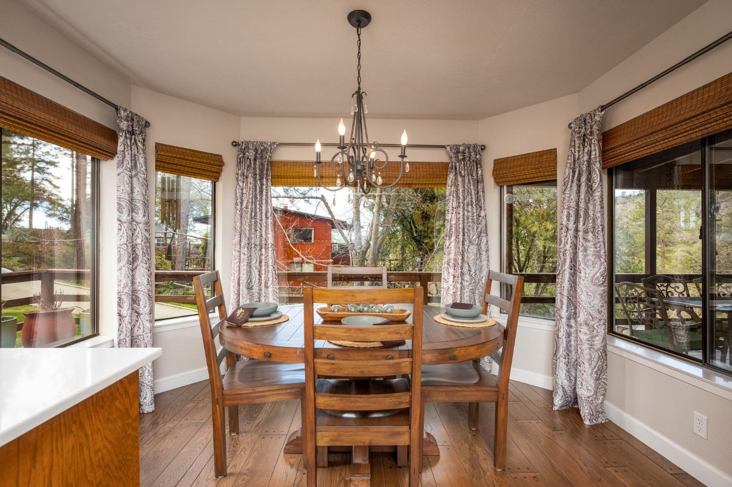 42538 Buckeye Road Oakhurst, CA 93644 - Photo 22 of 46 a view of a dining room with furniture large windows and wooden floor