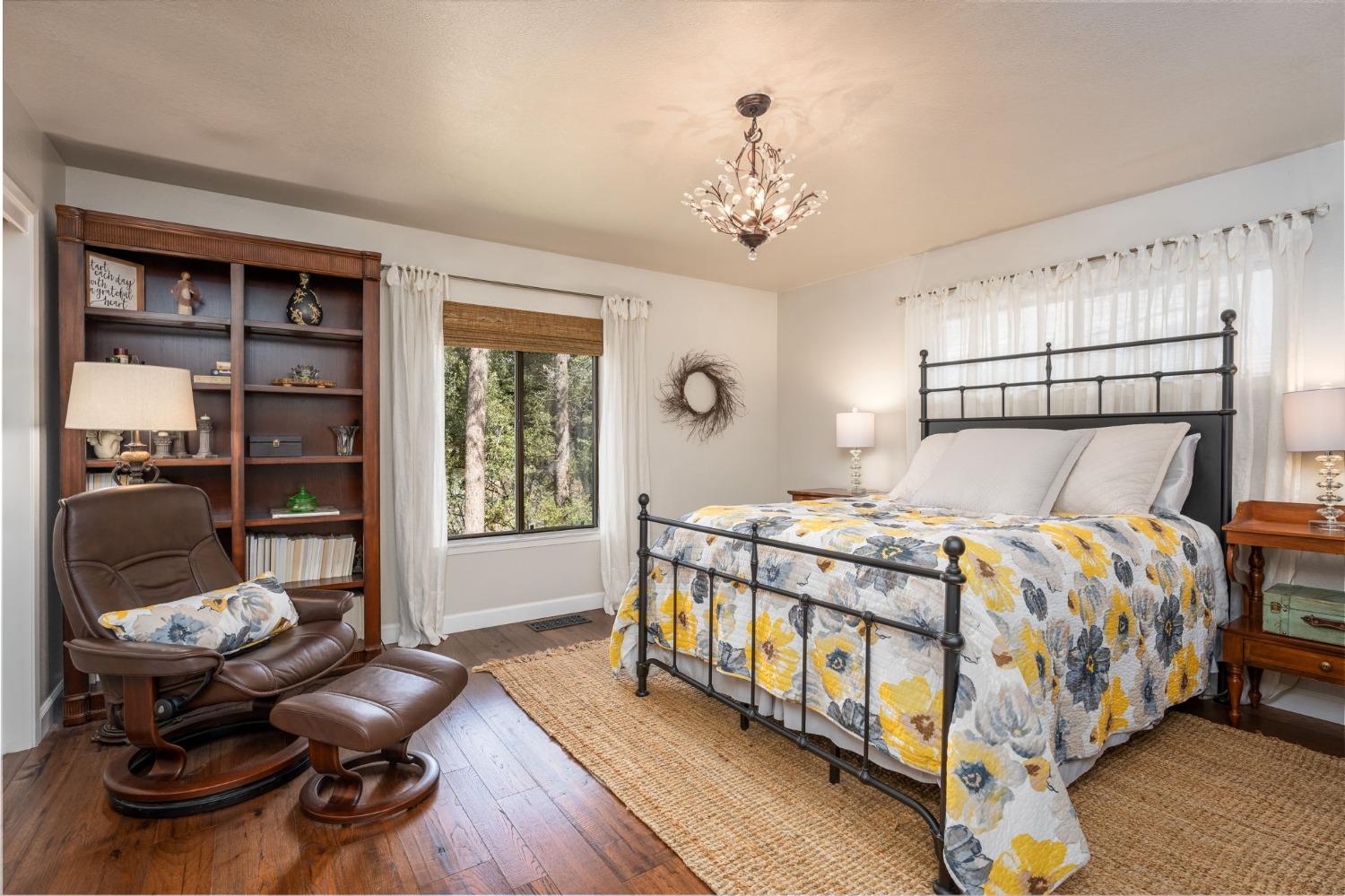 42538 Buckeye Road Oakhurst, CA 93644 - Photo 26 of 46 a bedroom with a bed and a chandelier