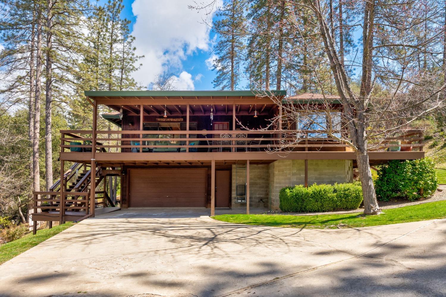 42538 Buckeye Road Oakhurst, CA 93644 - Photo 8 of 46 a front view of a house with a yard and potted plants