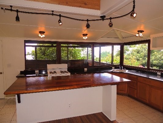 81-1073E Captain Cook Road, Unit B Captain Cook, HI 96704 - Photo 4 of 25 a kitchen with stainless steel appliances granite countertop a sink a stove and wooden cabinets