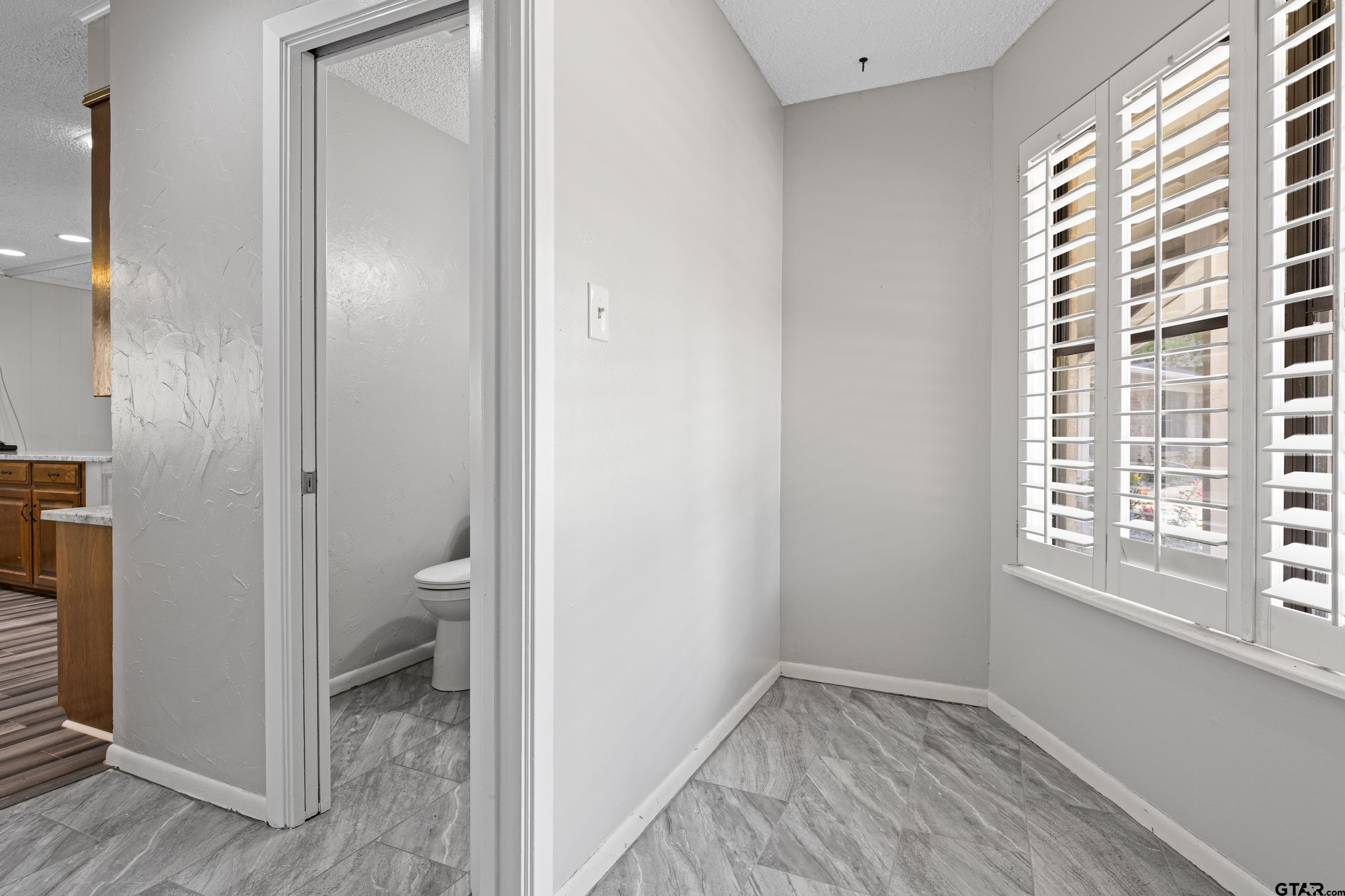 1821 Azalea Street Gilmer, TX 75644 - Photo 11 of 35 a bathroom with a toilet and a window