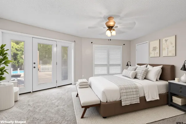 a bedroom with a large bed and a chandelier