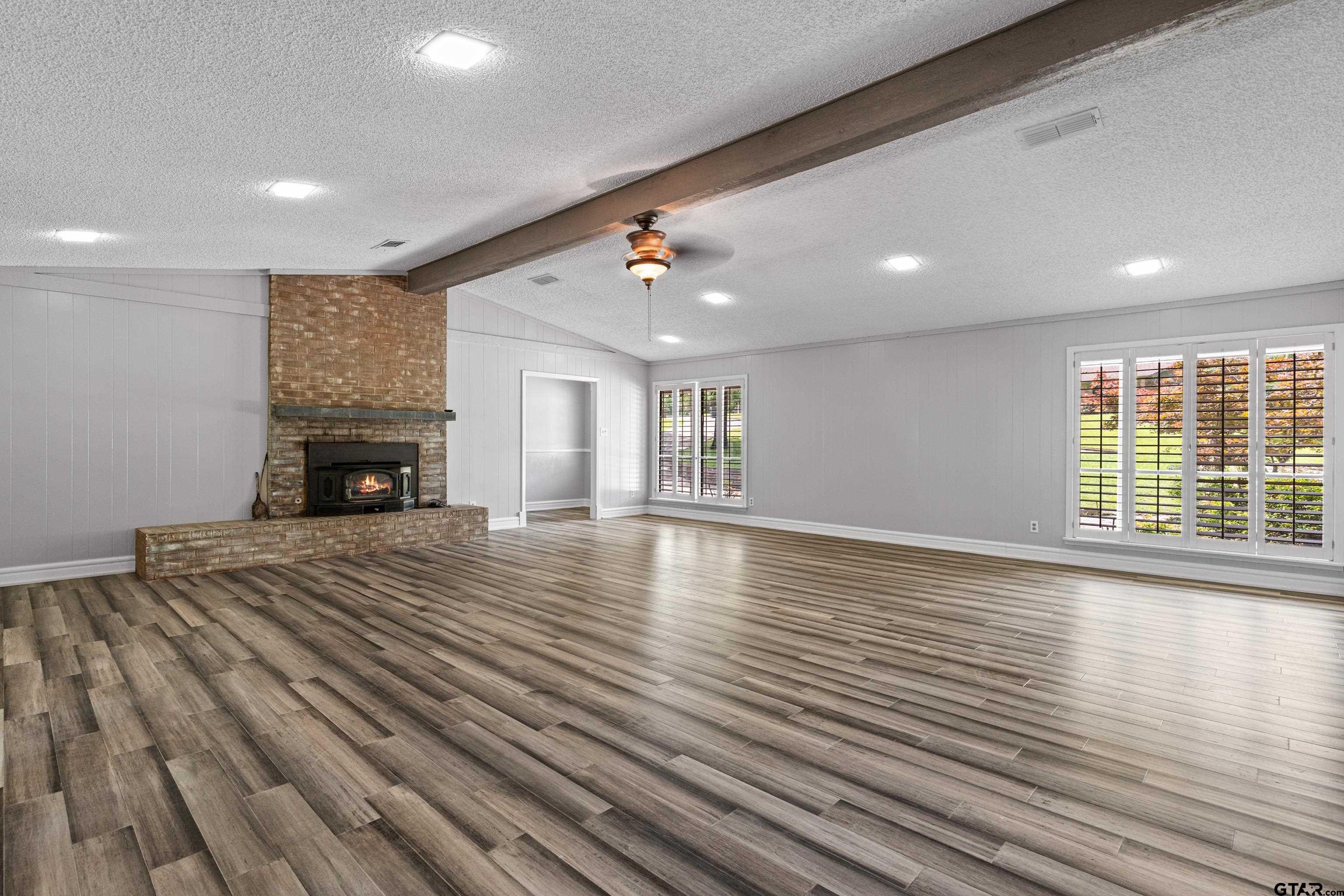 1821 Azalea Street Gilmer, TX 75644 - Photo 3 of 35 a view of empty room with wooden floor and fireplace