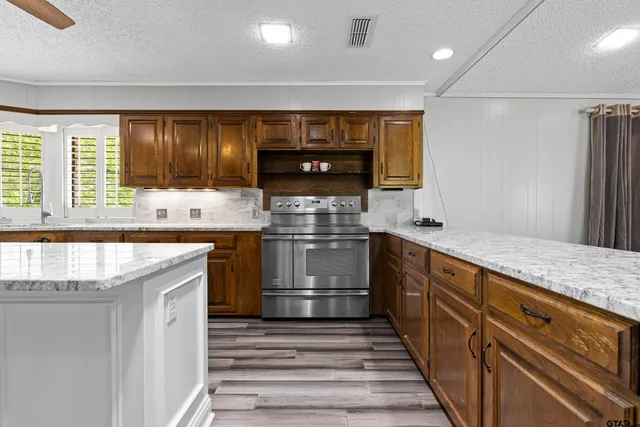 a kitchen with stainless steel appliances granite countertop a stove and a sink
