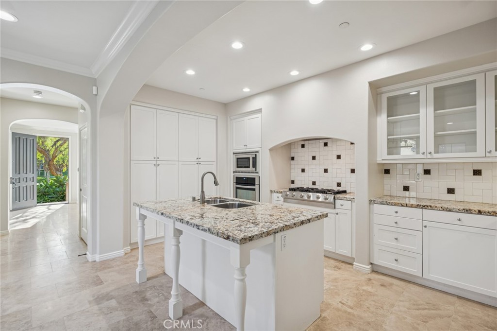 22 Ridge Valley Irvine, CA 92618 - Photo 11 of 37 a kitchen with granite countertop a sink a stove a dining table and chairs