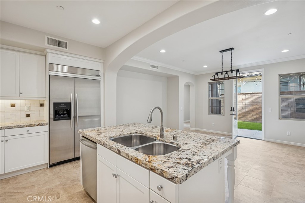 22 Ridge Valley Irvine, CA 92618 - Photo 13 of 37 a kitchen with kitchen island granite countertop a sink a counter top space appliances and cabinets
