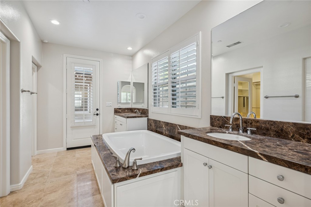 22 Ridge Valley Irvine, CA 92618 - Photo 17 of 37 a spacious bathroom with a granite countertop sink a mirror and a bathtub