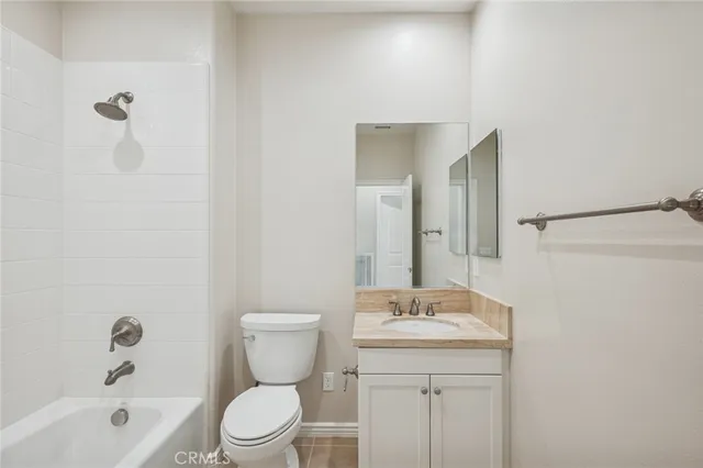 a bathroom with a granite countertop sink a toilet and shower