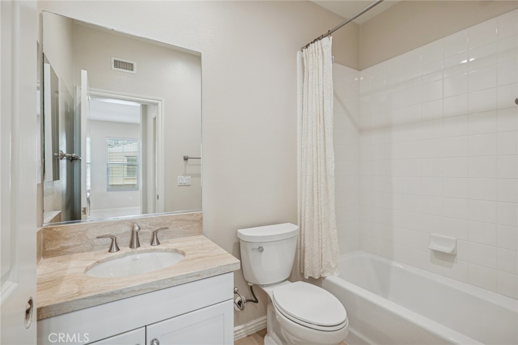 22 Ridge Valley Irvine, CA 92618 - Photo 25 of 37 a bathroom with a granite countertop toilet a sink and a mirror