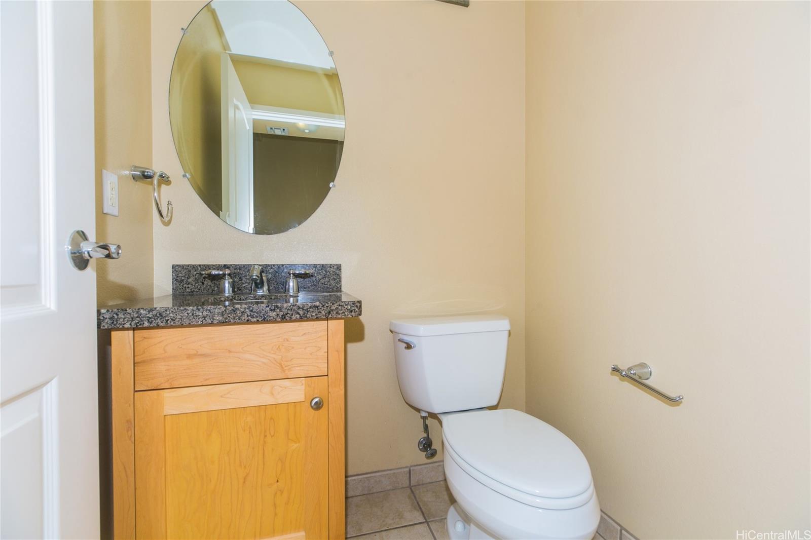 92-1516 Ali'inui Drive, Unit 1707 Kapolei, HI 96707 - Photo 19 of 23 a bathroom with a toilet mirror and vanity