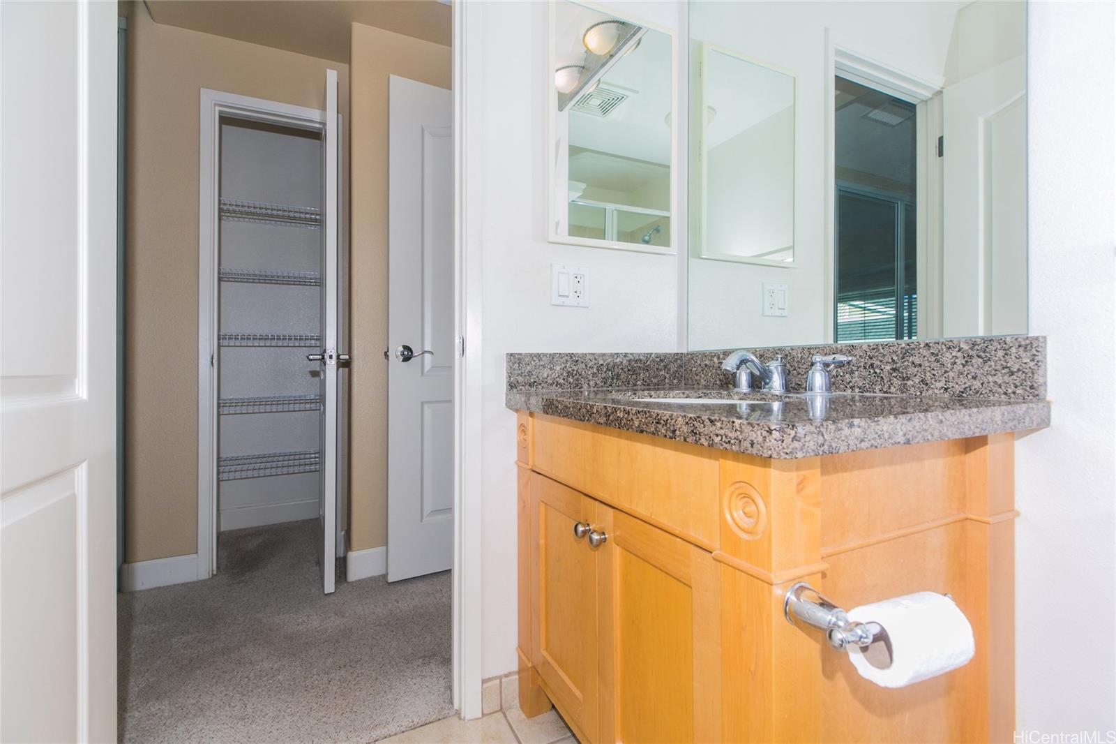 92-1516 Ali'inui Drive, Unit 1707 Kapolei, HI 96707 - Photo 8 of 23 a bathroom with a granite countertop sink and a mirror