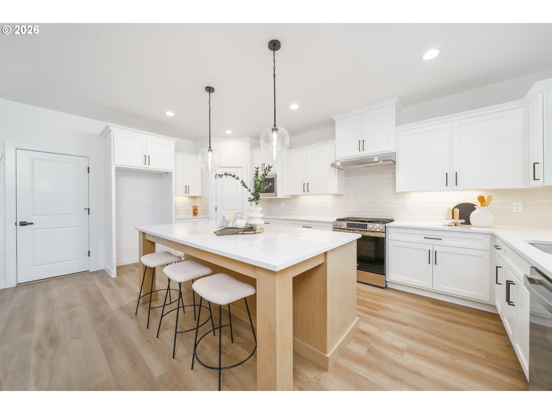 1908 Northwest 21st Circle Battle Ground, WA 98604 - Photo 15 of 40 a kitchen with a table chairs stove and white cabinets