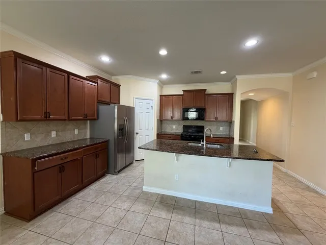 a large kitchen with stainless steel appliances and a sink