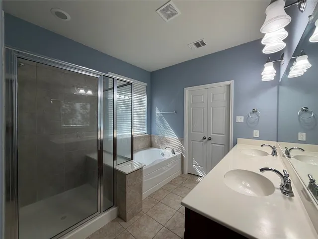 a en suite bathroom with a granite countertop sink a mirror and shower