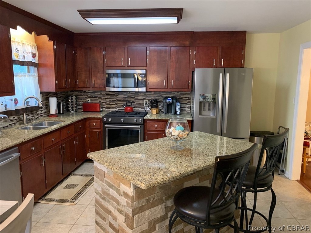 624 Butylo Road Laneview, VA 22504 - Photo 3 of 21 Open kitchen has been beautifully remodeled featuring Granite counters, tile backsplash and floor, Stainless appliances and island/breakfast bar.