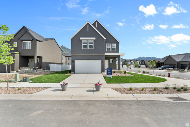 722 West 2840 South, Unit 8 Logan, UT 84321 - Photo 1 of 23 View of front facade with a residential view, an attached garage, driveway, and stucco siding