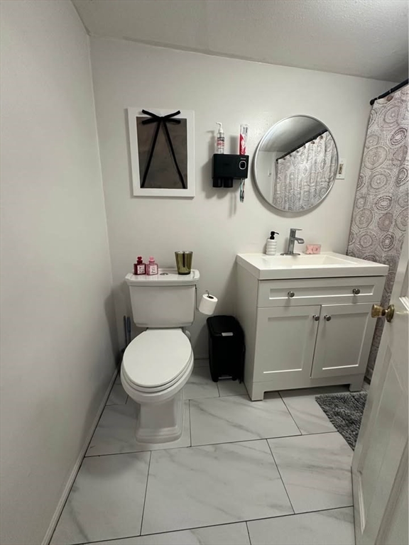 2 Prospect Street, Unit 2 Haverhill, MA 01832 - Photo 7 of 14 a bathroom with a toilet a sink and mirror