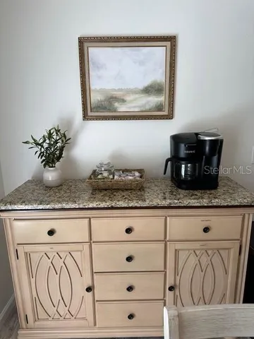a sink with granite countertop white cabinets and a granite top