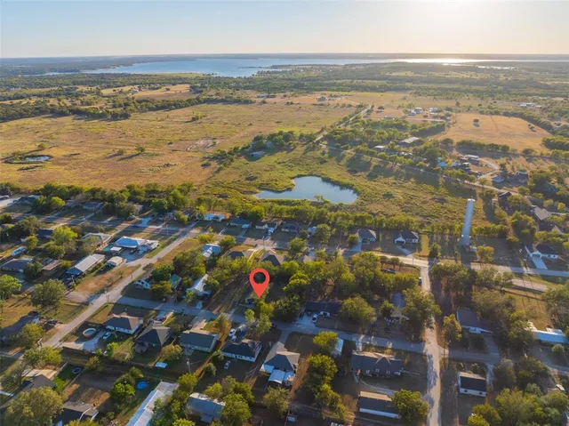 an aerial view of residential houses with outdoor space and trees