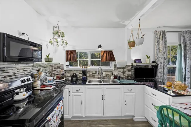 a kitchen with stainless steel appliances a stove sink microwave and cabinets
