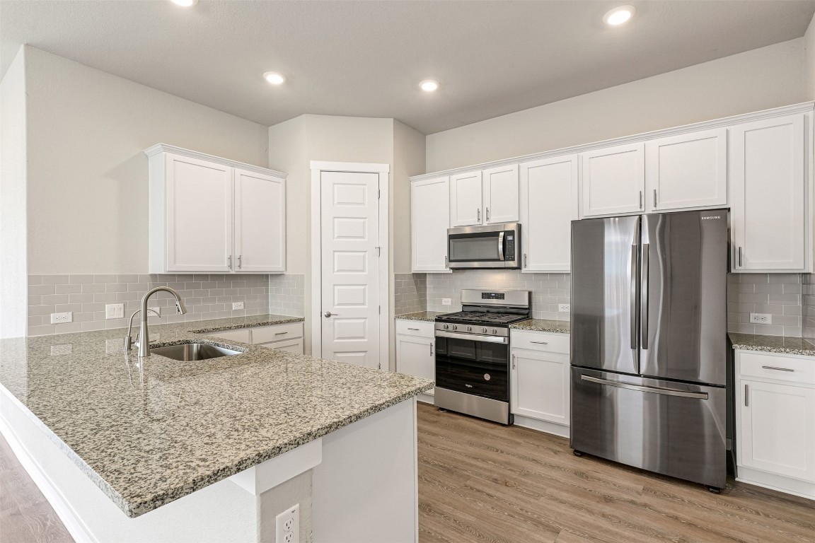 2016 Bobtail Pass Leander, TX 78641 - Photo 11 of 40 a kitchen with stainless steel appliances granite countertop a sink stove and refrigerator