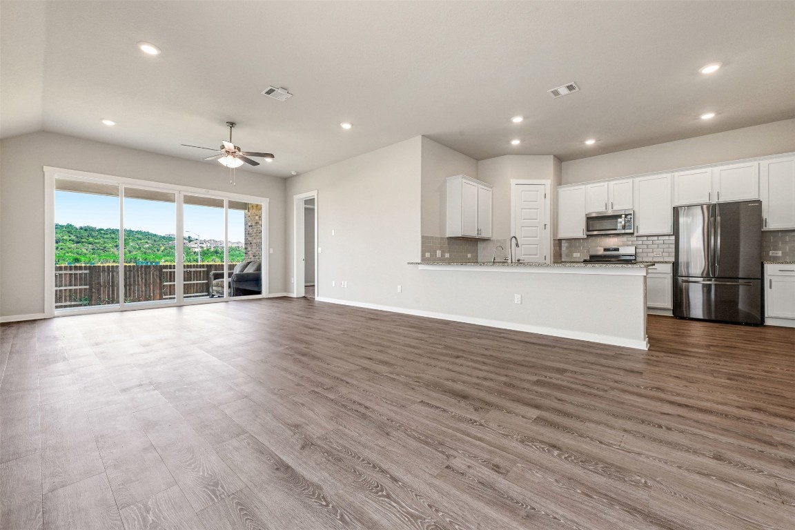 2016 Bobtail Pass Leander, TX 78641 - Photo 6 of 40 a view of a kitchen with refrigerator and wooden floor