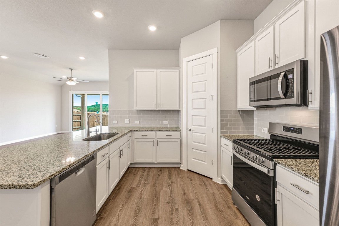 2016 Bobtail Pass Leander, TX 78641 - Photo 8 of 40 a kitchen with stainless steel appliances granite countertop a stove a sink and a microwave