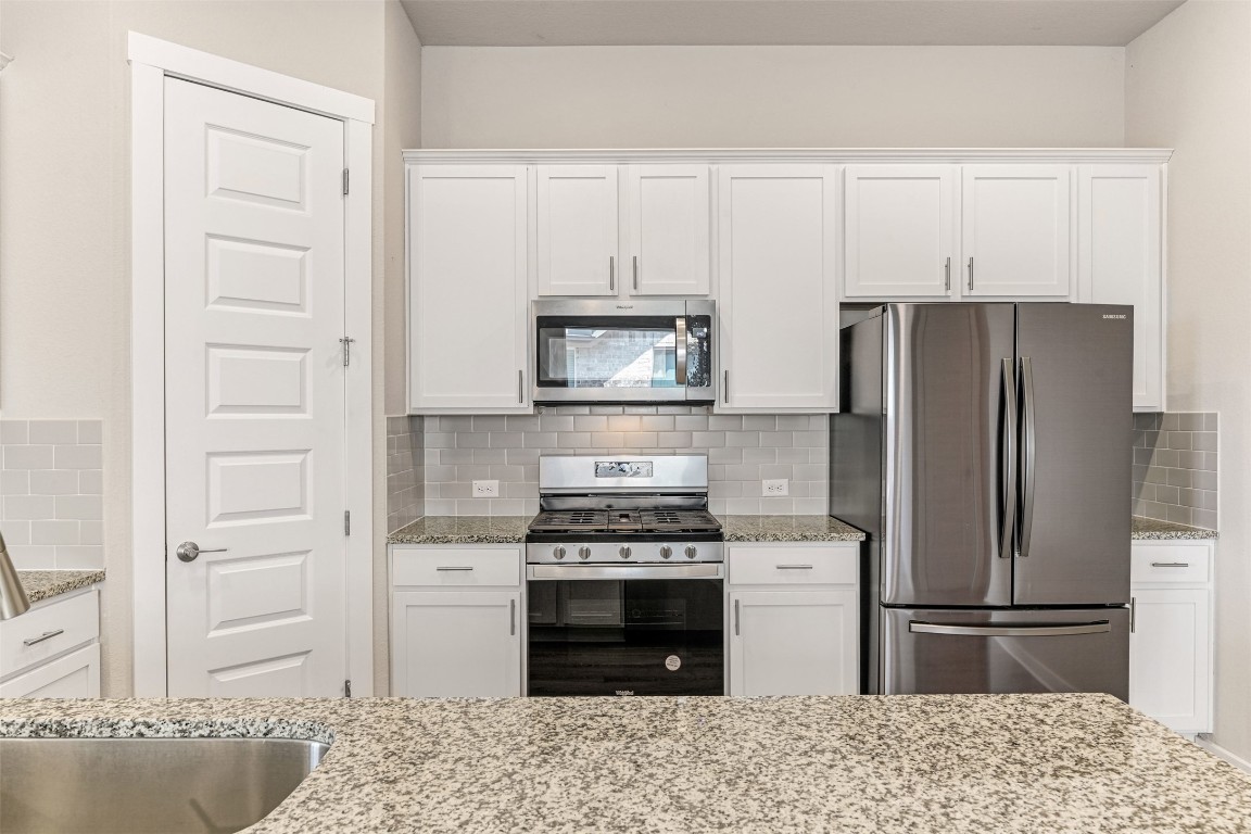 2016 Bobtail Pass Leander, TX 78641 - Photo 10 of 40 a kitchen with a refrigerator stove and wooden cabinets
