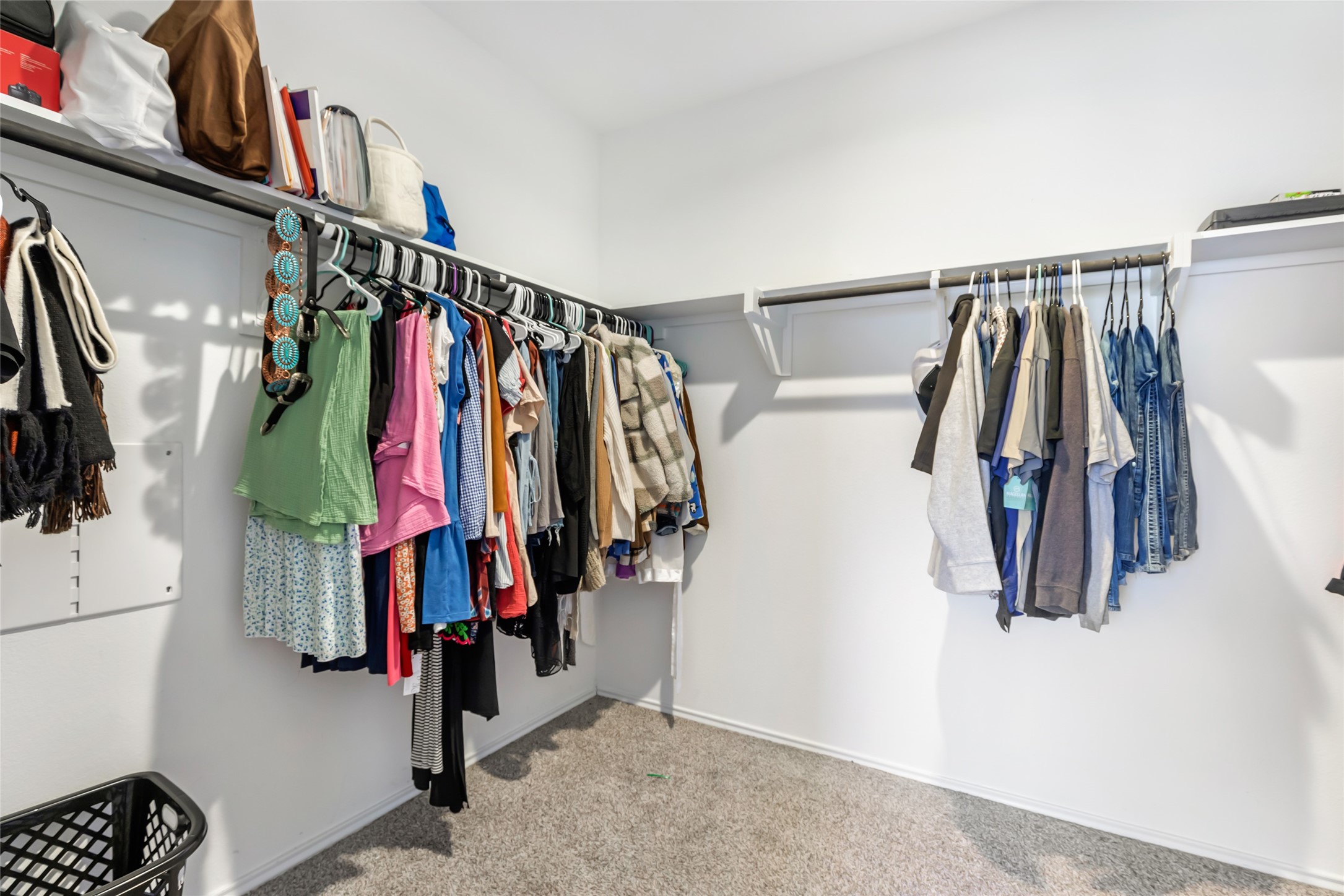 811 Republic Road New Caney, TX 77357 - Photo 33 of 37 Spacious walk-in closet with ample hanging space and shelving, perfect for organizing clothes and accessories. Neutral carpeting adds warmth.
