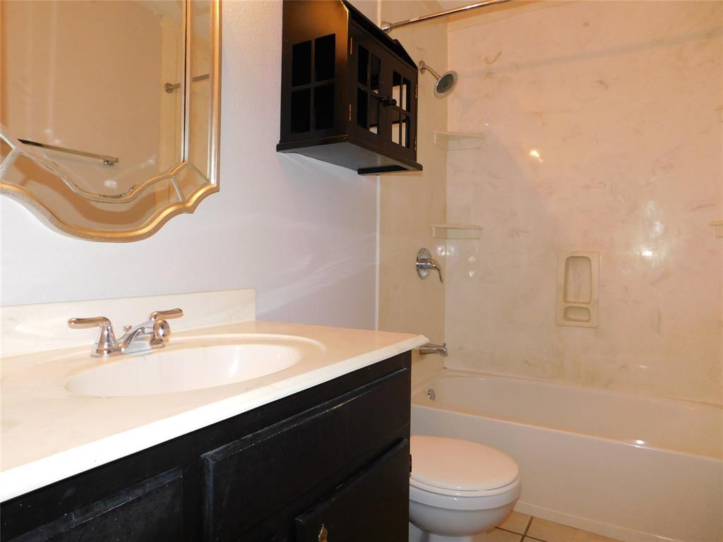 714 North Ruddell Street Denton, TX 76209 - Photo 12 of 20 a bathroom with a sink a toilet a mirror and bathtub