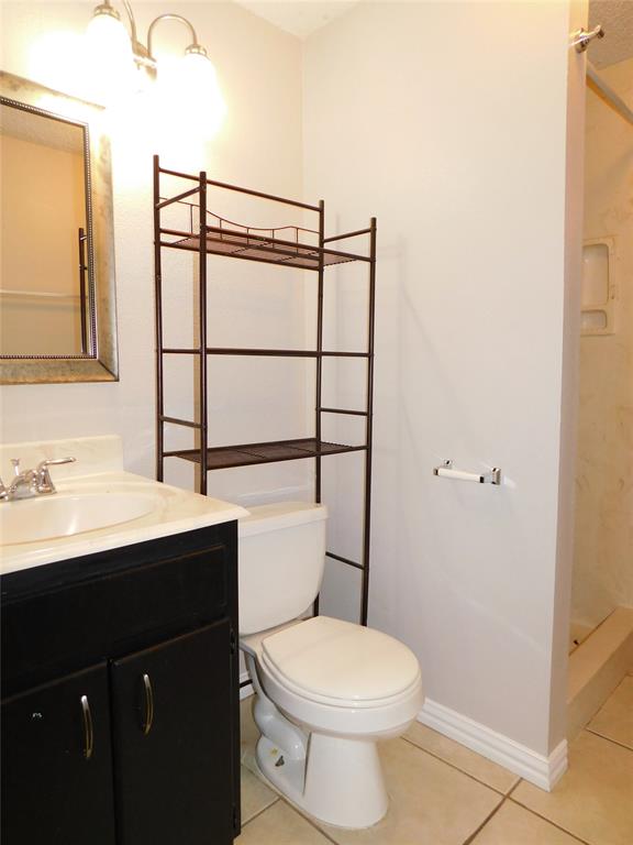 714 North Ruddell Street Denton, TX 76209 - Photo 15 of 20 a bathroom with a toilet a sink and mirror