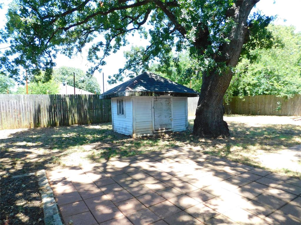 714 North Ruddell Street Denton, TX 76209 - Photo 17 of 20 a backyard of a house with table and chairs under a large tree