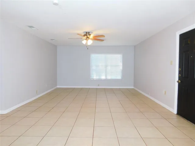 an empty room with windows and ceiling fan view