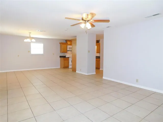 an empty room with closet and a chandelier fan
