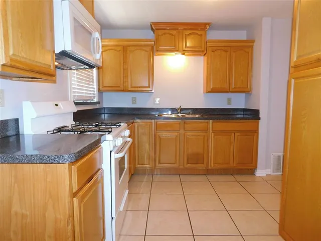 a kitchen with stainless steel appliances granite countertop a sink and a stove