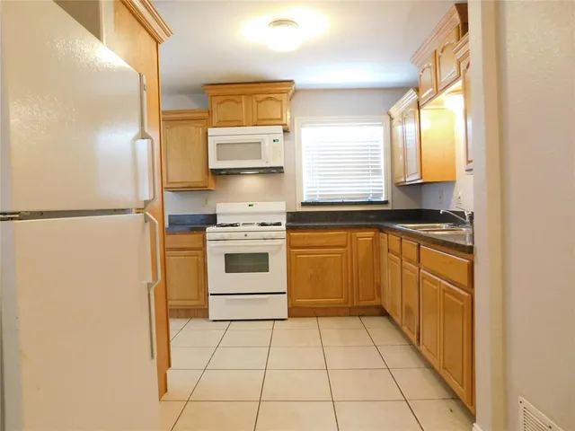 a kitchen with a refrigerator sink and stove top oven