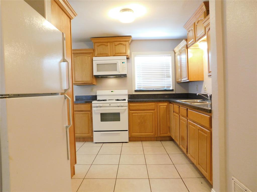 714 North Ruddell Street Denton, TX 76209 - Photo 7 of 20 a kitchen with a refrigerator sink and stove top oven