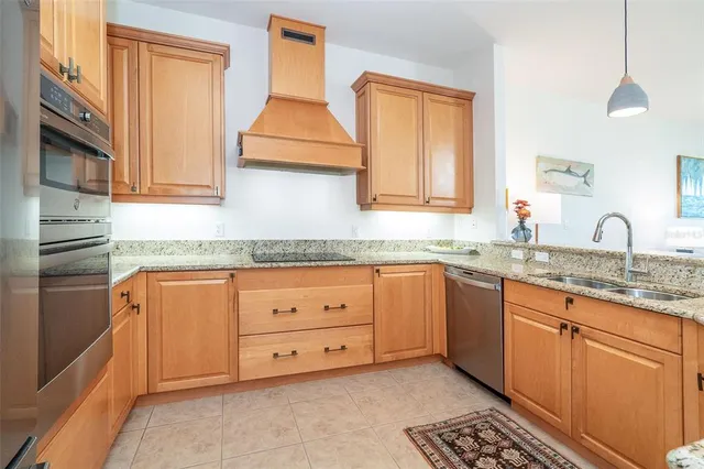 a kitchen with stainless steel appliances granite countertop a sink a stove and a refrigerator