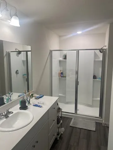 a bathroom with a double vanity sink mirror and shower